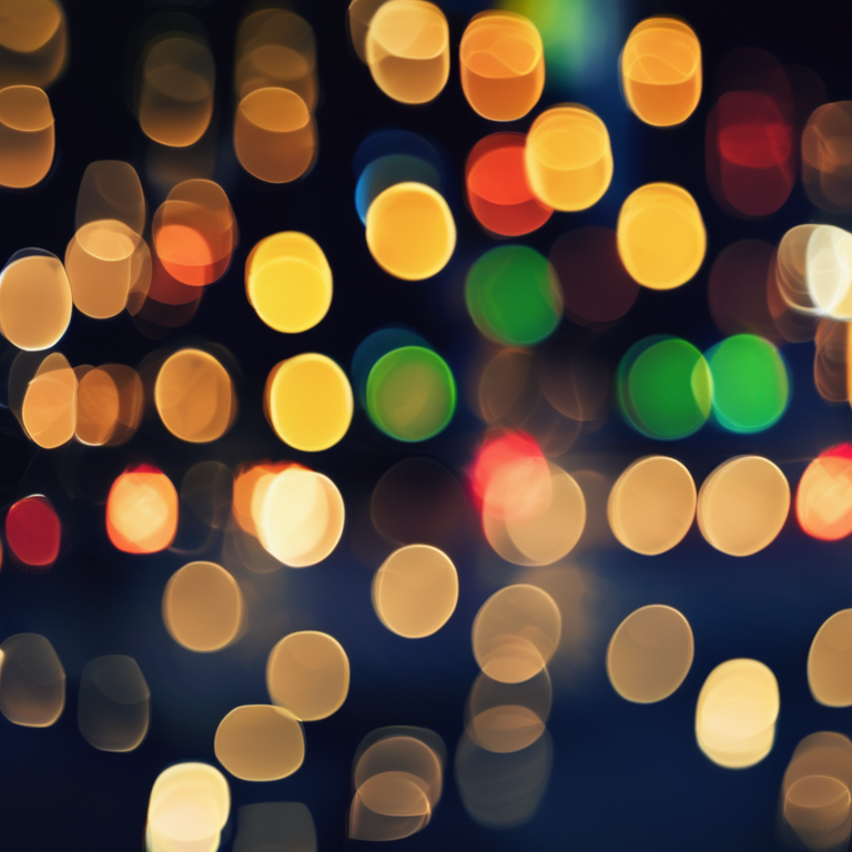 Bokeh abstract — out-of-focus city lights forming circles of colored light on black